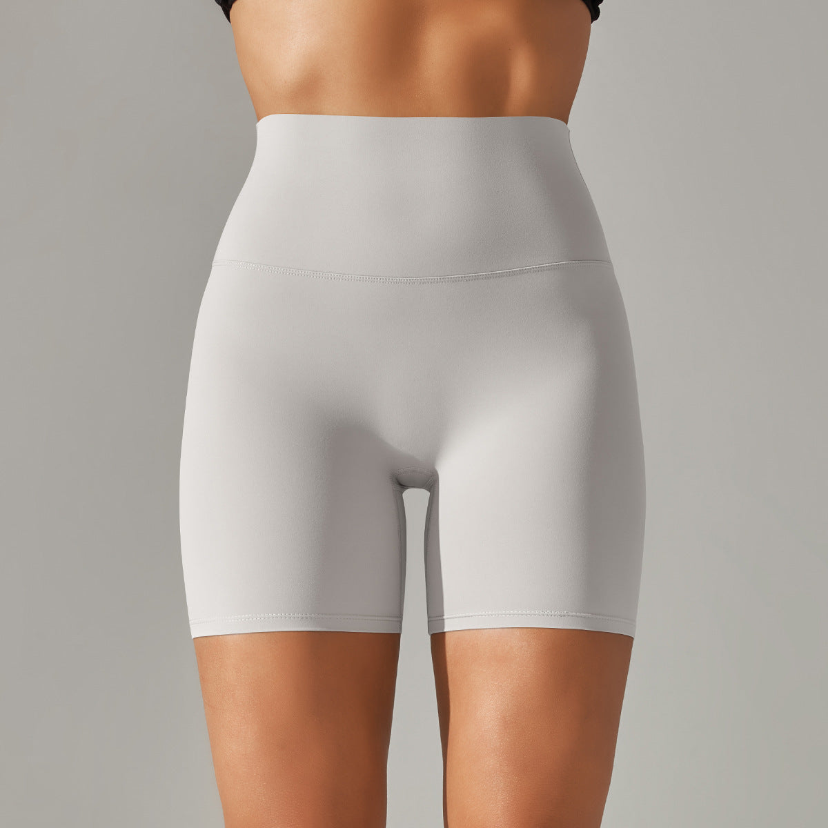 Light gray high-waisted shorts worn by a person on a gray background