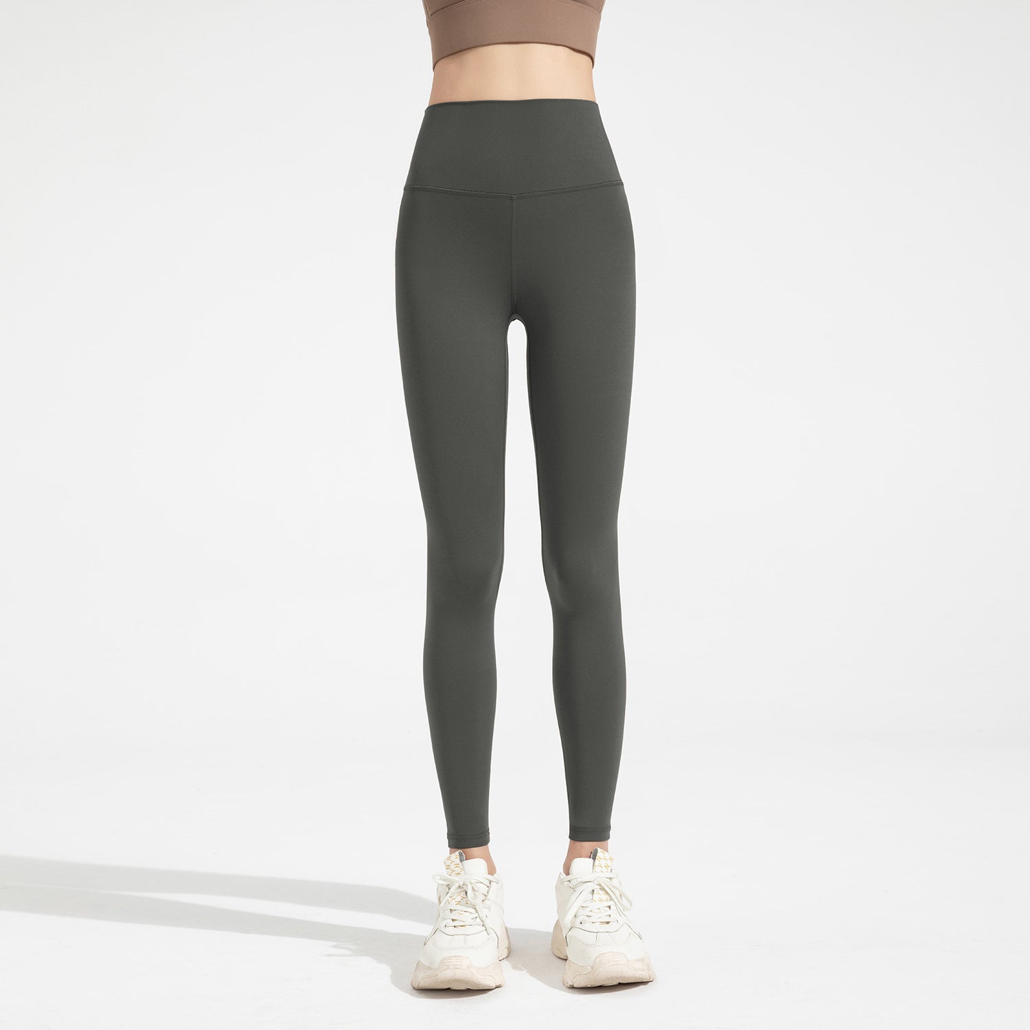 Person wearing dark gray leggings on a white background