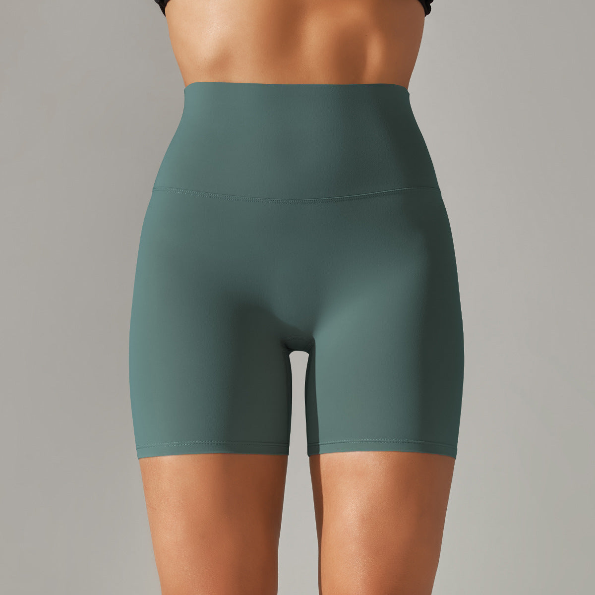 Green athletic shorts worn by a person on a gray background