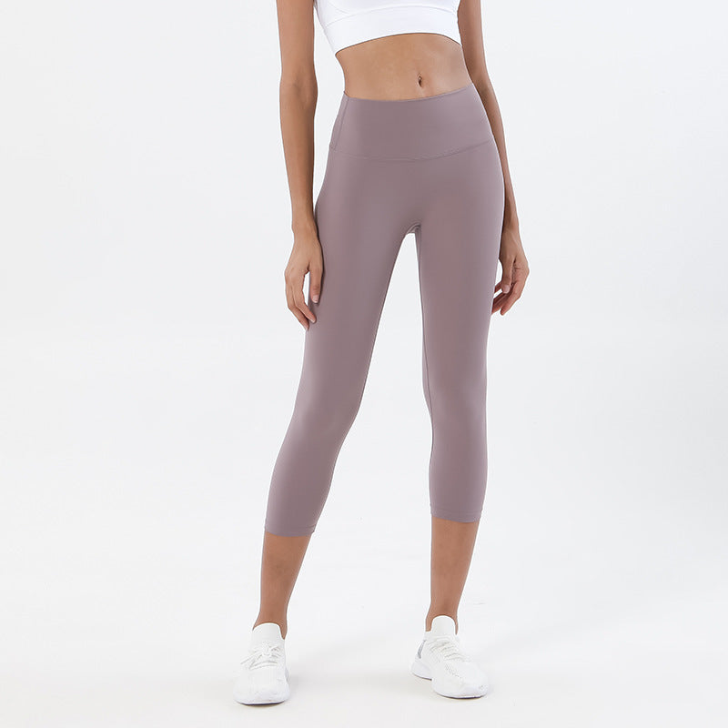 Person wearing mauve leggings on a white background