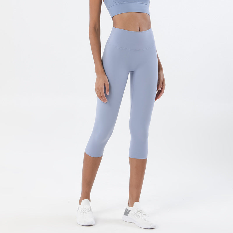 Person wearing light blue leggings and a matching top on a white background