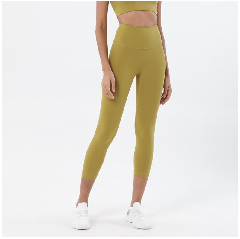 Person wearing green leggings and a matching top on a white background