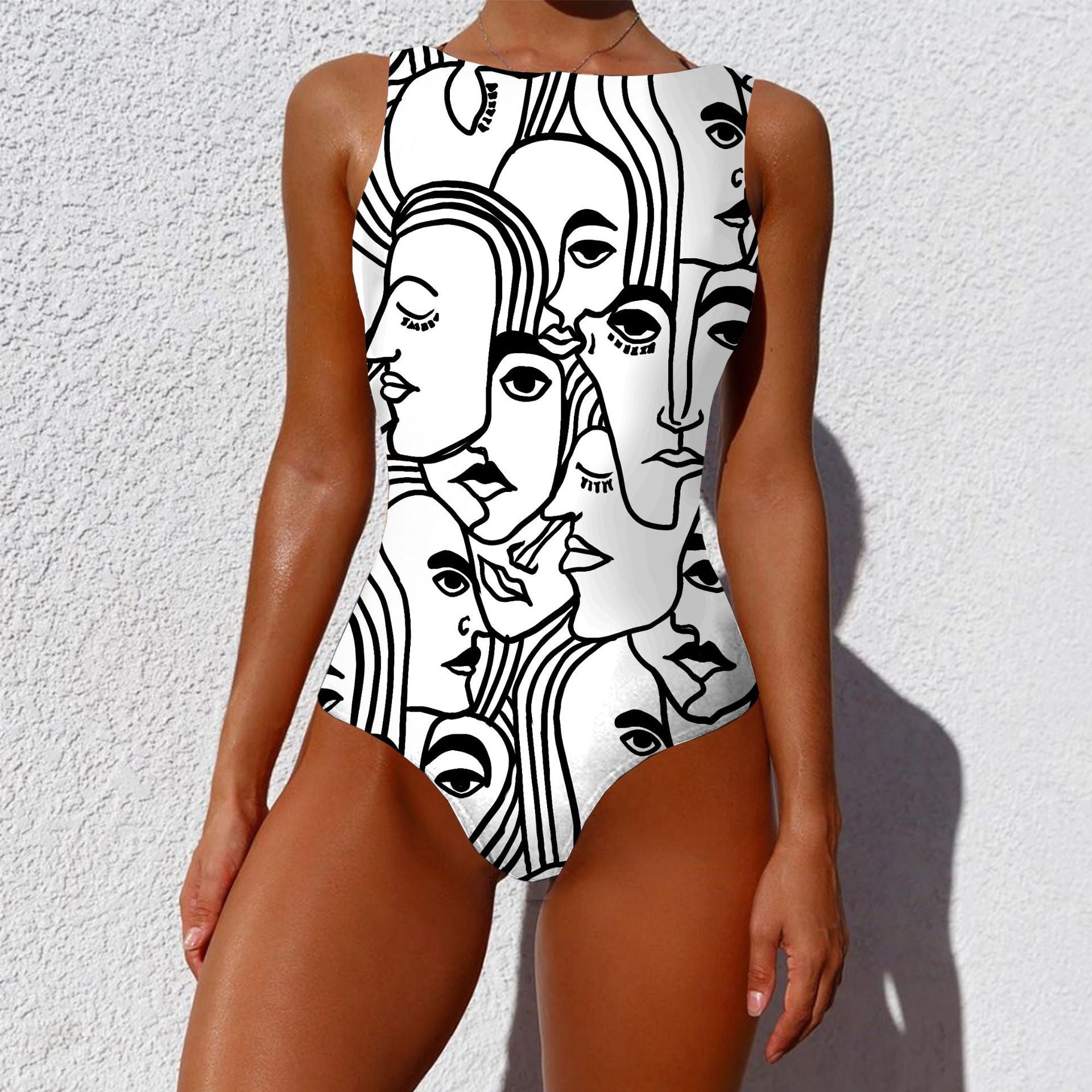 Person wearing a one-piece swimsuit with black and white abstract face design against a white background