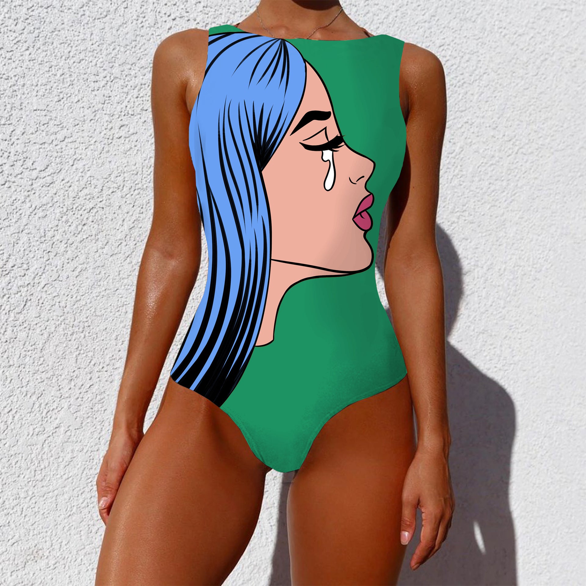 Person wearing a green swimsuit with a stylized face design against a white background