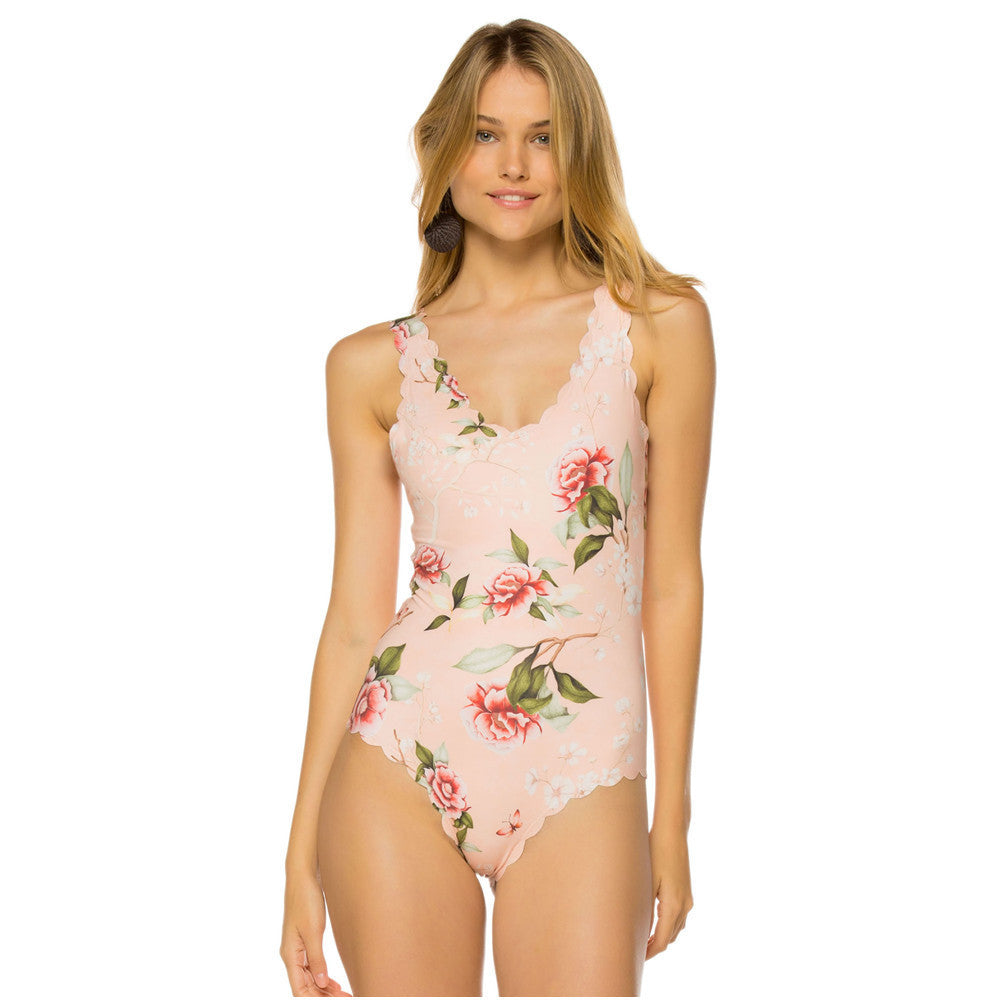 Woman wearing a floral one-piece swimsuit on a white background