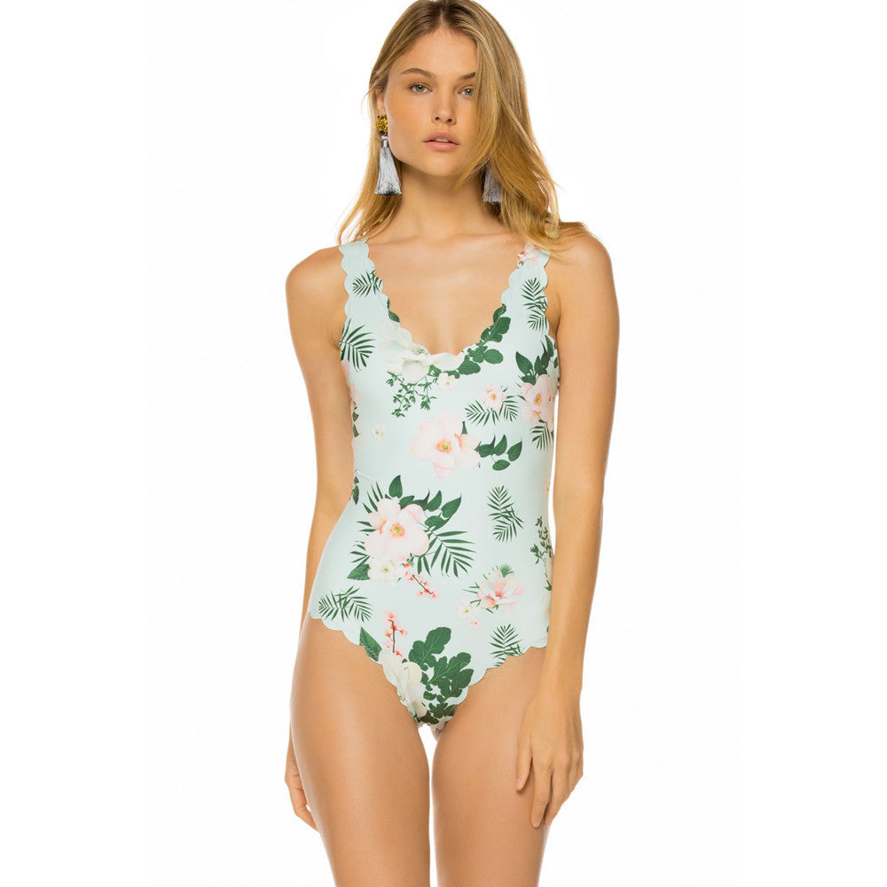 Woman wearing a floral one-piece swimsuit on a white background