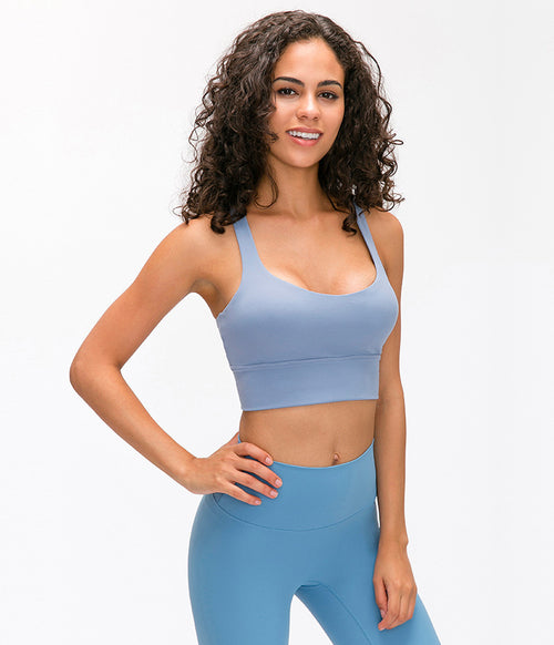 Woman wearing a blue sports bra and leggings on a white background