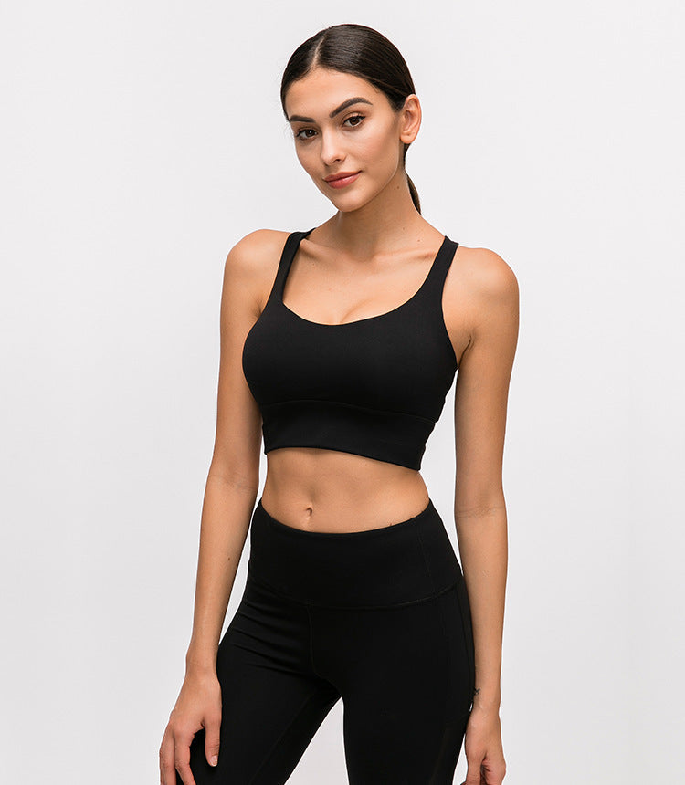 Woman wearing a black athletic outfit on a light gray background