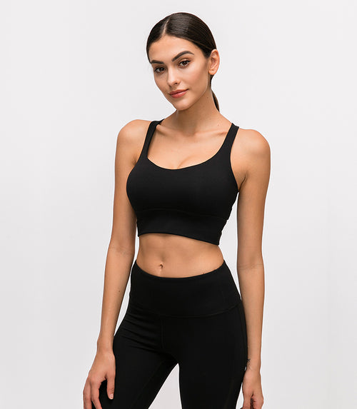 Woman wearing a black athletic outfit on a light gray background