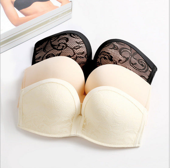 Beige strapless bra with black lace trim on a white background