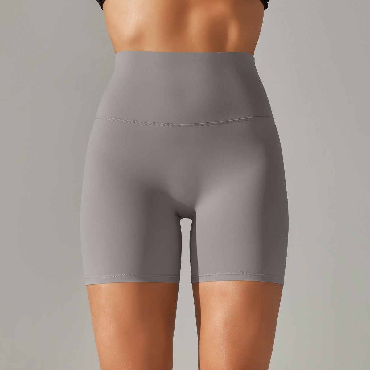 Gray high-waisted shorts worn by a person on a gray background