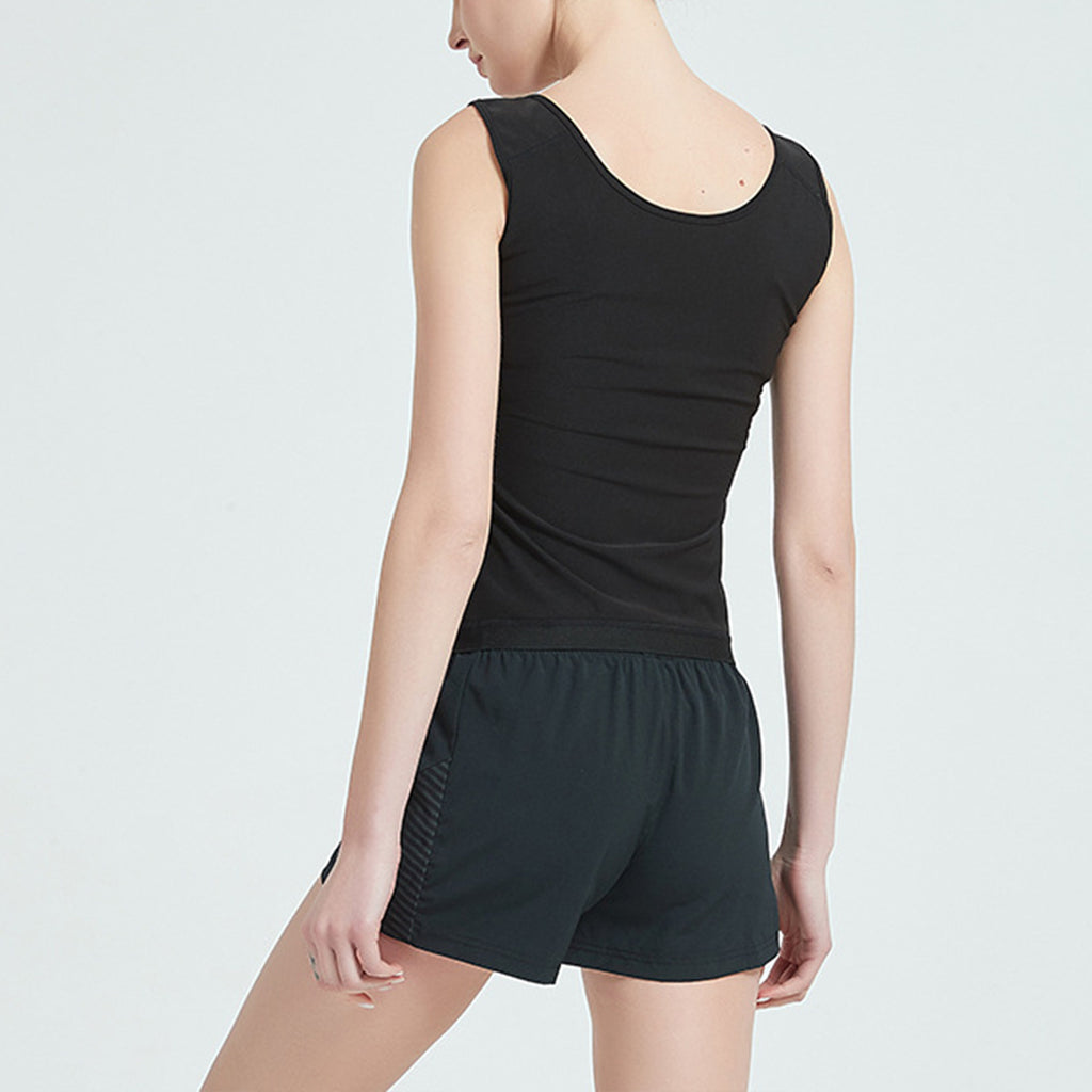 Person wearing a black tank top and shorts on a light gray background