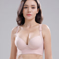 Woman wearing a light pink bra against a gray background