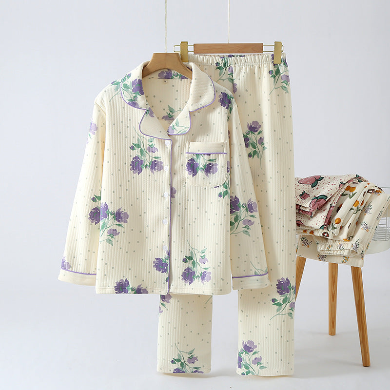 Floral pajama set on a hanger with a chair and folded fabric in the background.