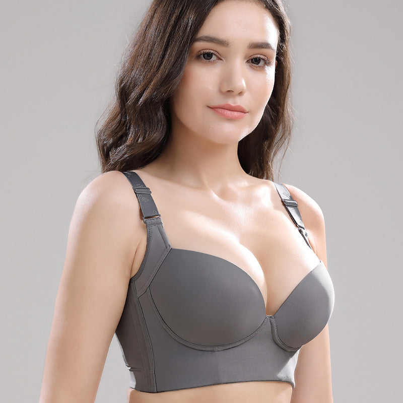 Woman wearing a gray bra against a plain background
