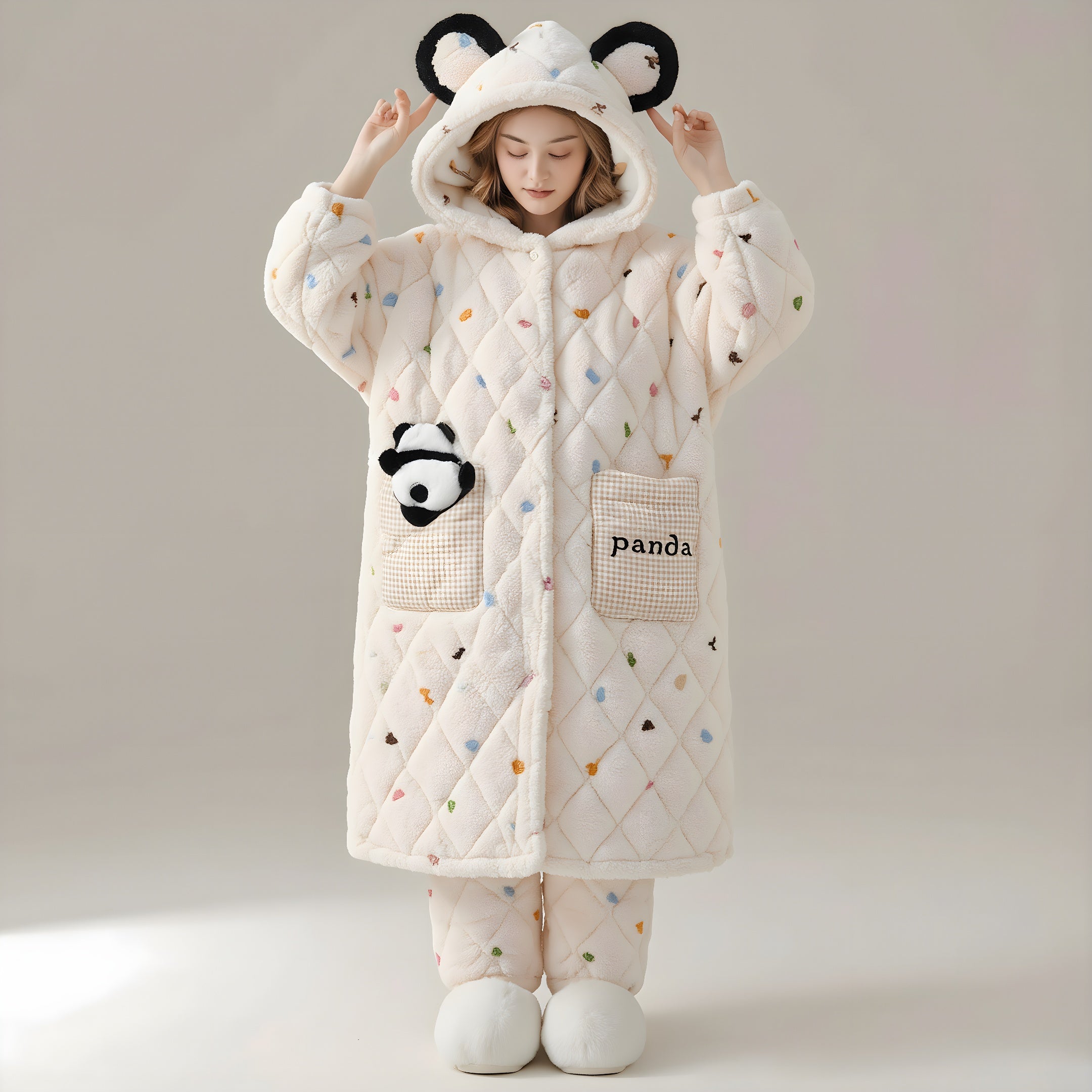 Person wearing a white quilted coat with panda design and ears on a neutral background