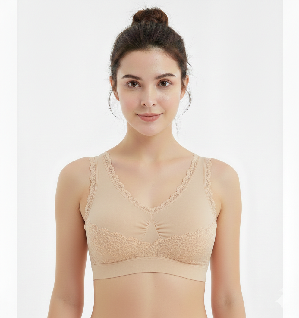 Woman wearing a beige lace-trimmed bralette against a white background