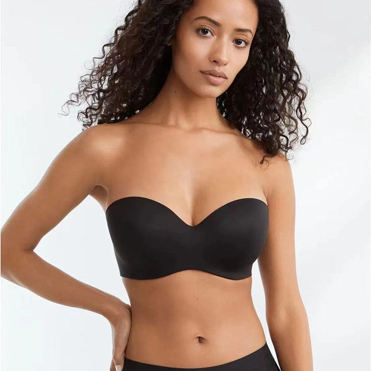 Woman wearing a black strapless bra against a white background