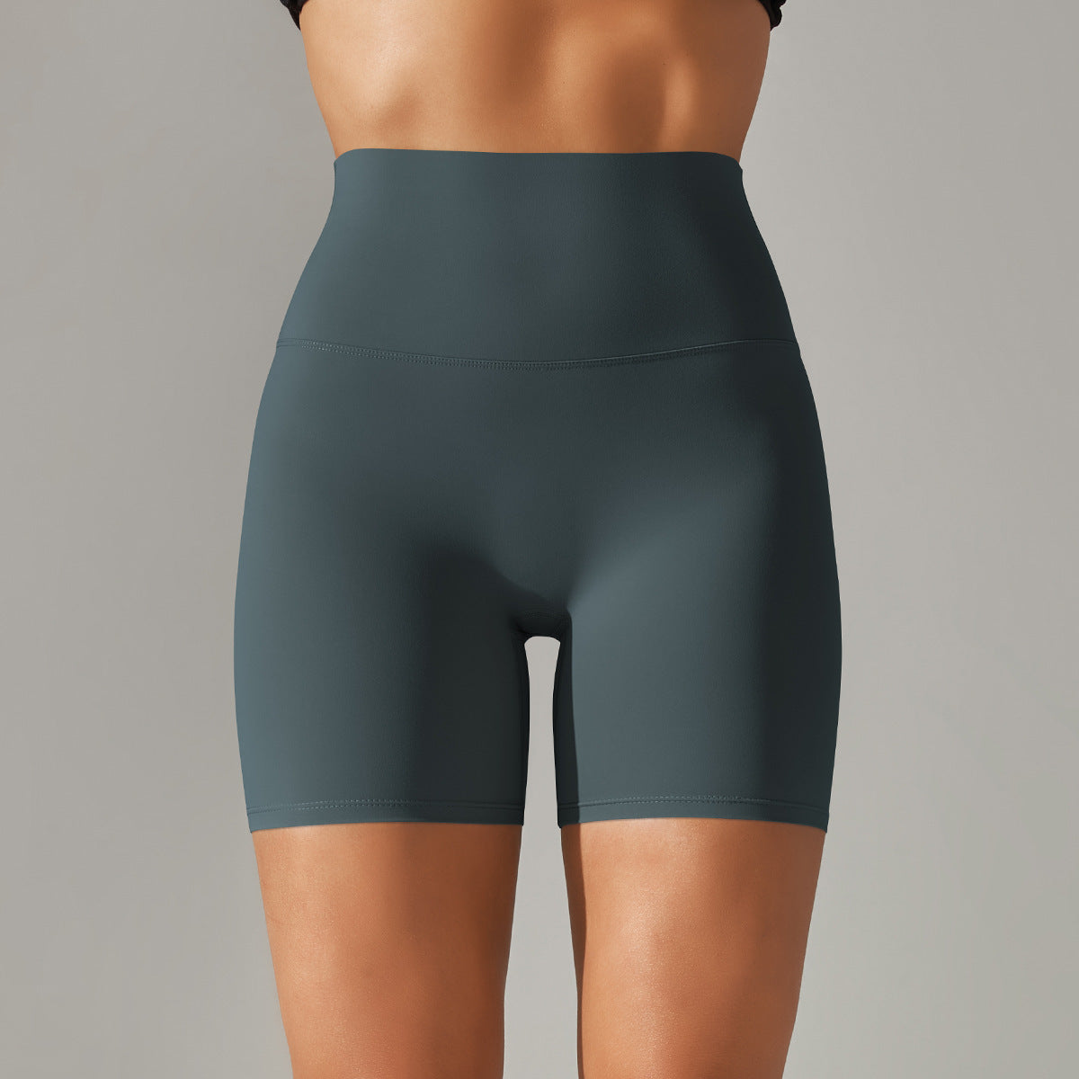 Dark green athletic shorts worn by a person on a gray background