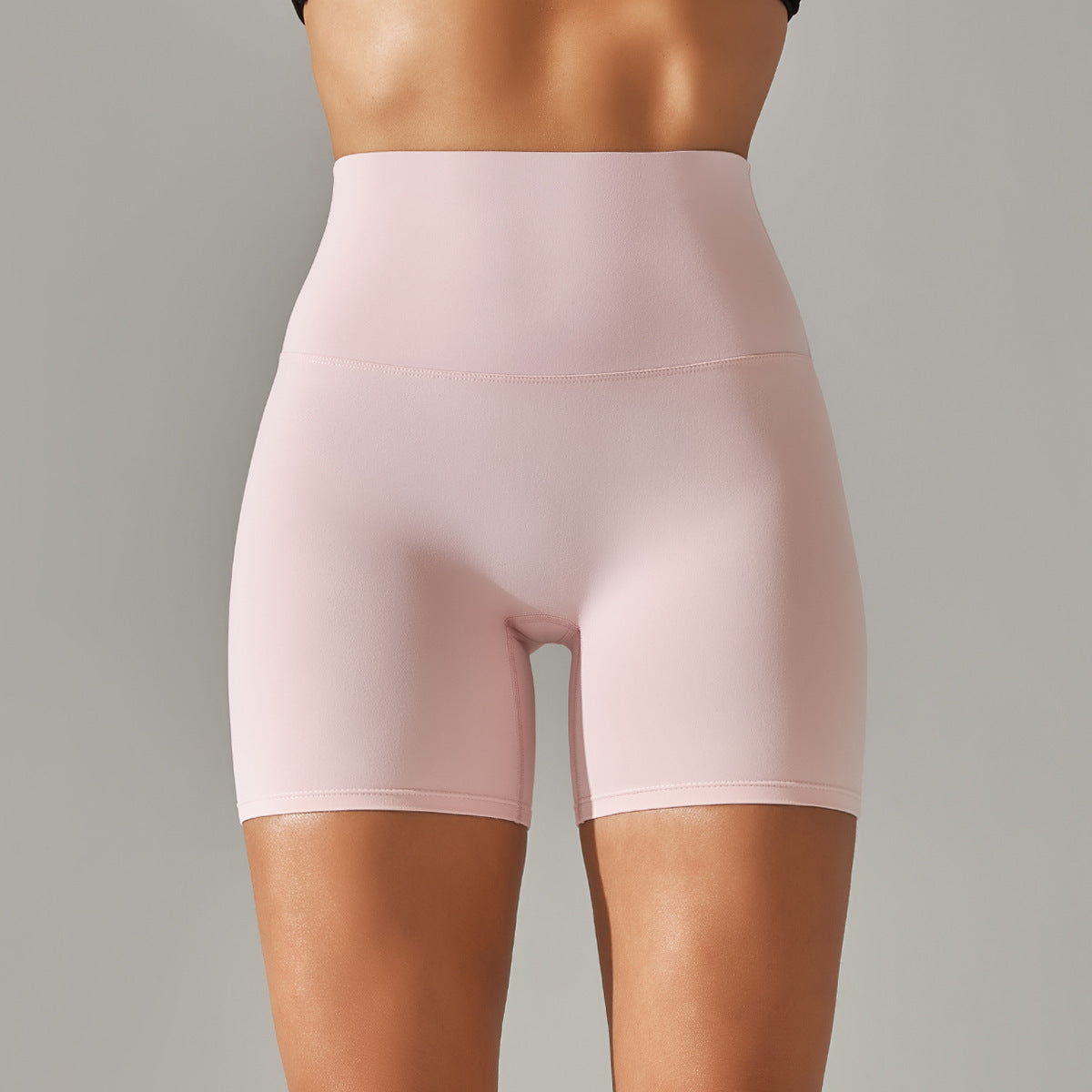 Pink high-waisted shorts on a gray background