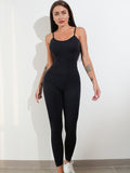 Woman wearing a black jumpsuit against a white background