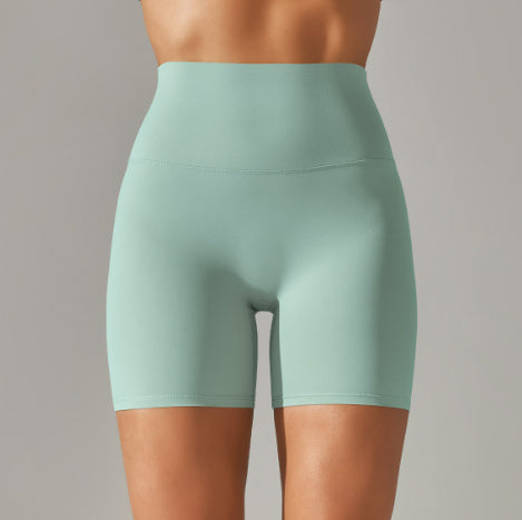 Mint green athletic shorts worn by a person on a gray background