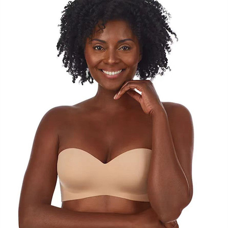 Woman wearing a beige strapless bra on a white background