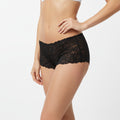 Black lace underwear worn by a person on a white background