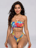 Woman wearing a colorful tie-dye bikini against a gray background