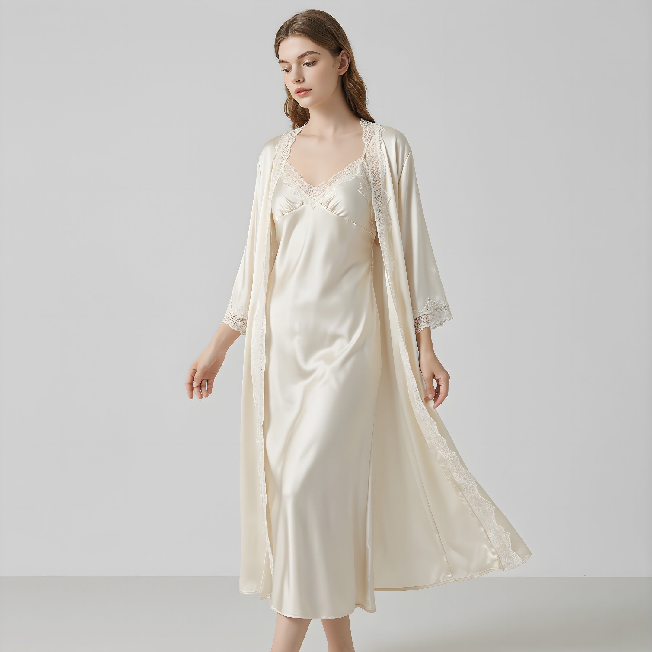 Woman wearing a cream satin nightgown with matching robe on a light gray background