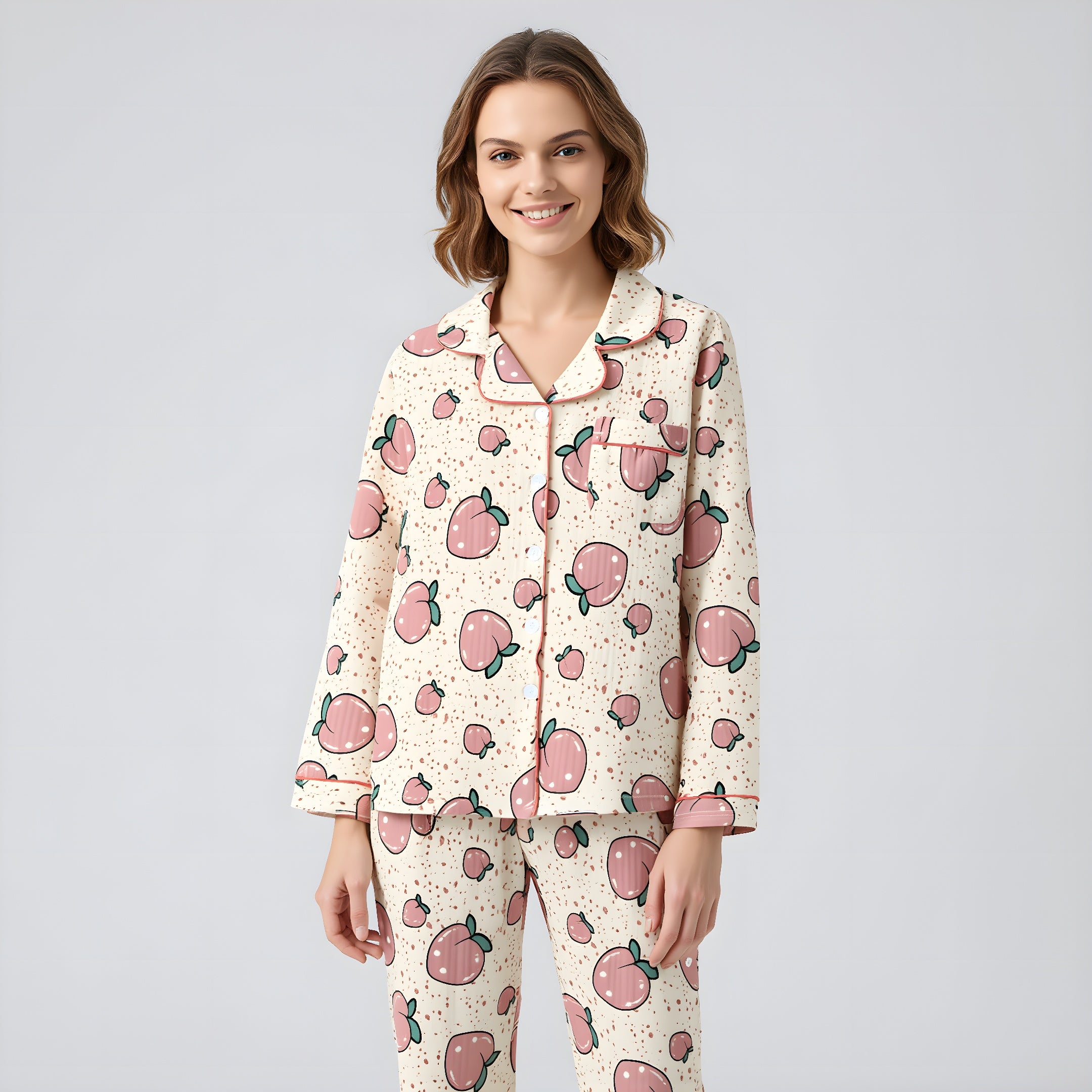 Woman wearing a pajama set with pink apple pattern on a light gray background