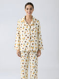 Woman wearing a patterned pajama set on a plain background