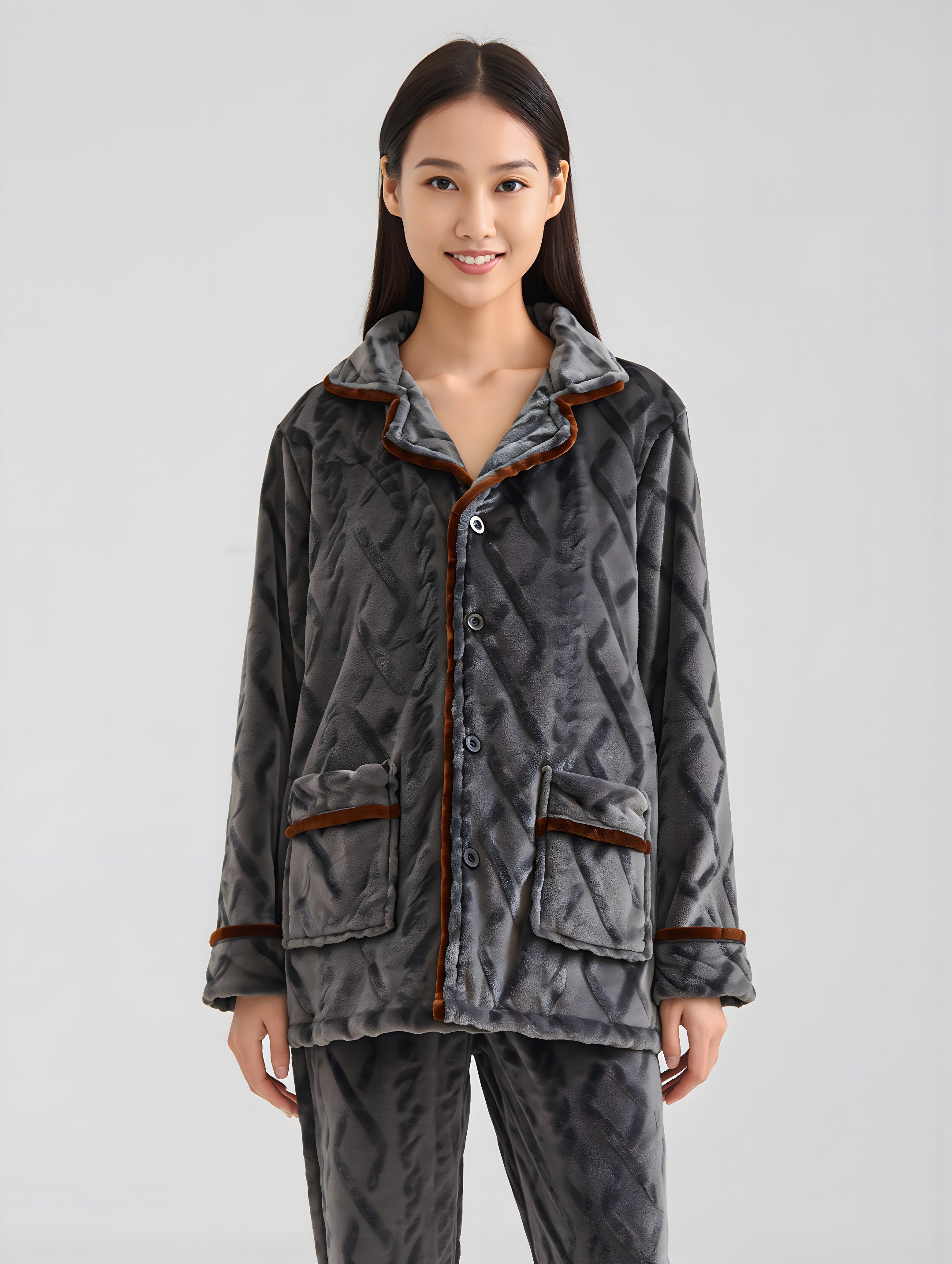 Woman wearing a gray quilted jacket with brown trim on a light gray background