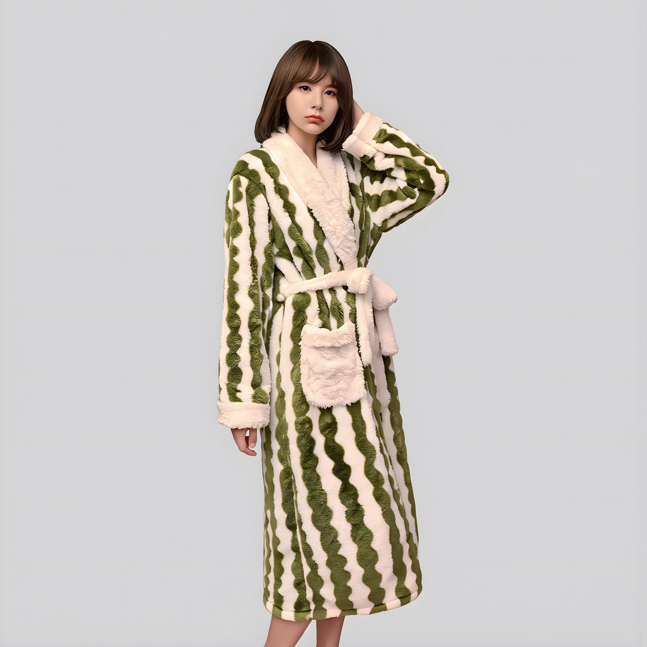 Woman wearing a green and white striped robe with a hood on a gray background