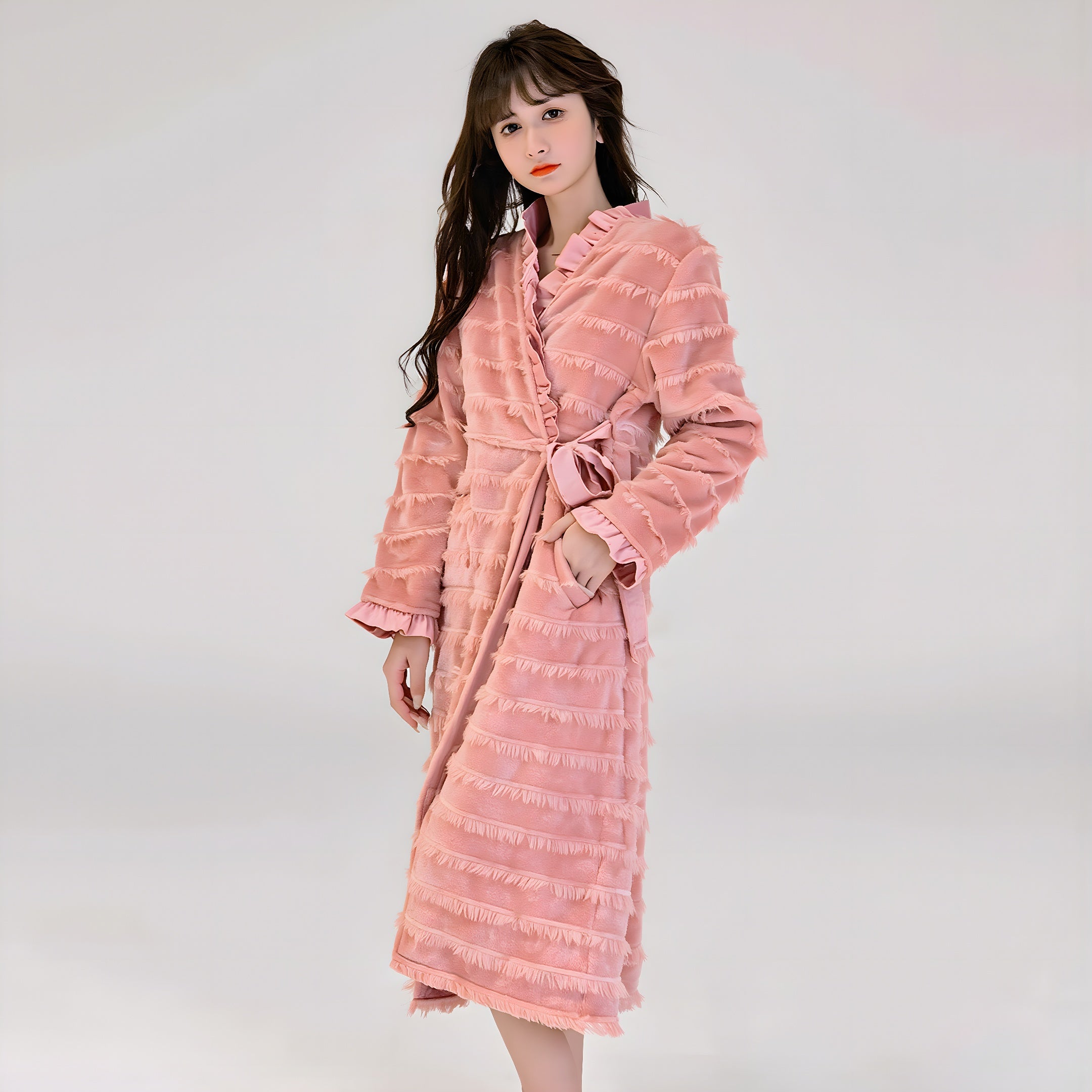 Woman wearing a pink textured robe against a white background