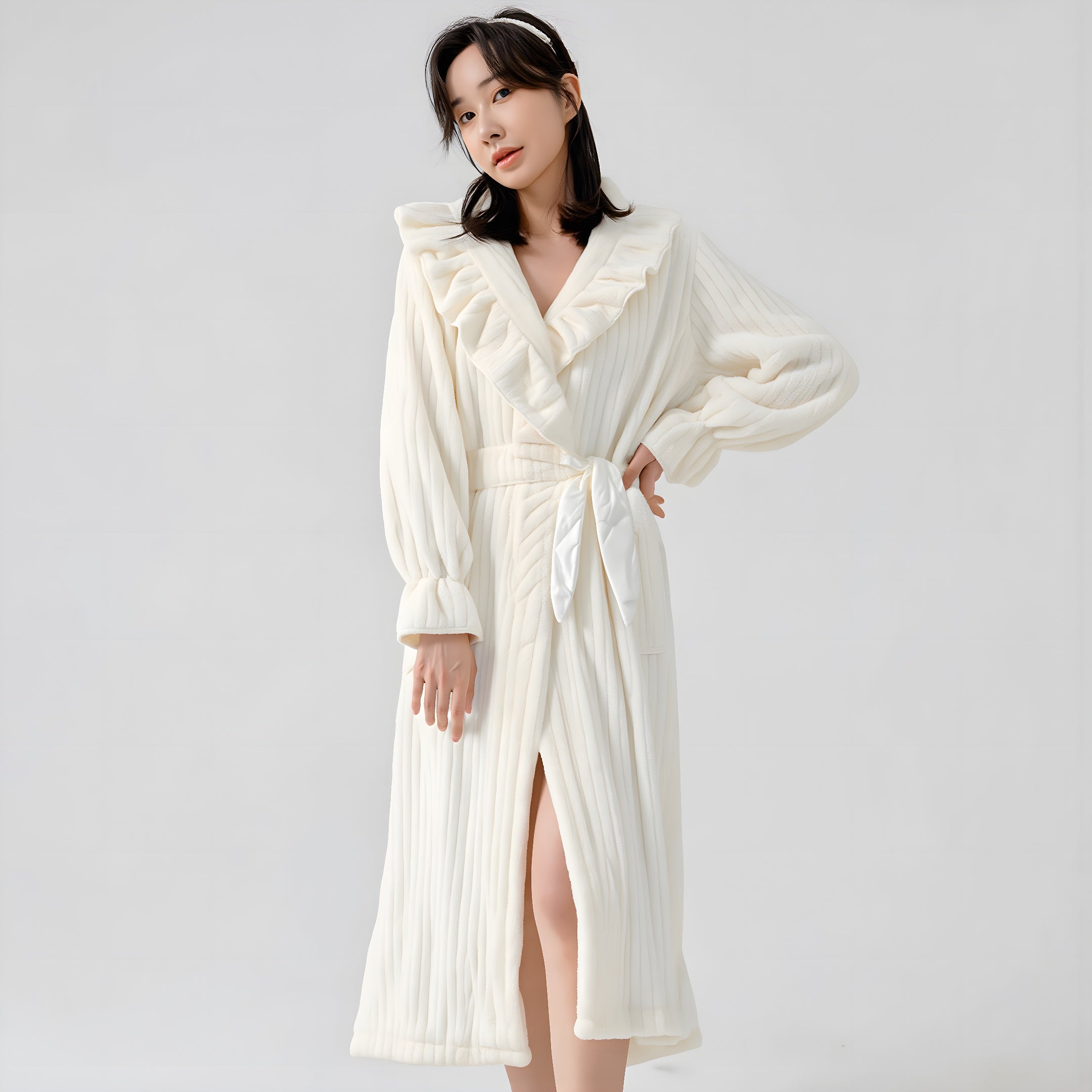Woman wearing a white ribbed robe against a plain background